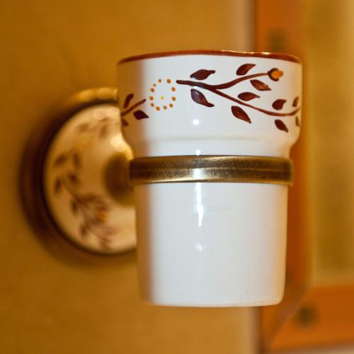 a cup with a flower pattern on it next to a clock at Casa Wagner in Braşov