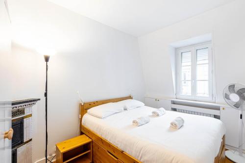 une chambre avec un lit avec des draps blancs et une fenêtre dans l'établissement GuestReady - Paris Escape with Eiffel Views, à Paris