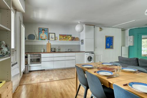 Il dispose d'une cuisine et d'un salon avec une table et des chaises en bois. dans l'établissement 3 bedroom apartment with balconies, à Paris