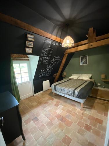 a bedroom with a bed in a room with green walls at Domaine de la Maroutière in Saint-Fort