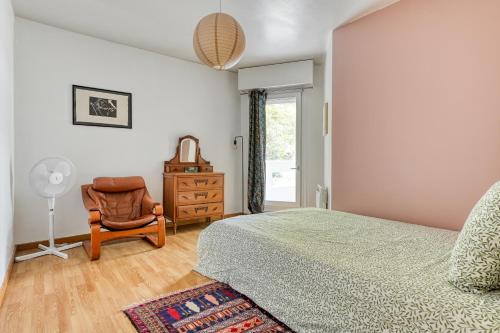 une chambre avec un lit, une chaise et une fenêtre dans l'établissement 3 bedroom apartment with balconies, à Paris