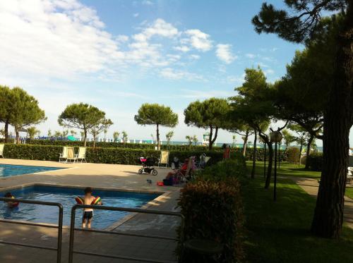 uma pessoa na piscina de um resort em RESIDENCE GARDEN -WALTERIGATO Apartments SOLO PER FAMIGLIE em Lido di Jesolo
