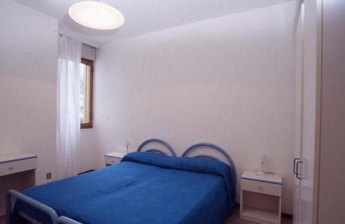 a bedroom with a blue bed and a window at RESIDENCE GARDEN -WALTERIGATO Apartments SOLO PER FAMIGLIE in Lido di Jesolo