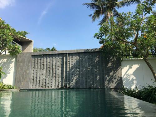 a swimming pool in front of a fence at Samten Saigon River Retreat in Thuan An