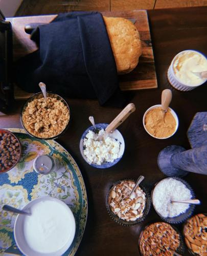 a table topped with plates of food and bowls of cereal at Blind Tiger Portland - Carleton Street Guest House in Portland