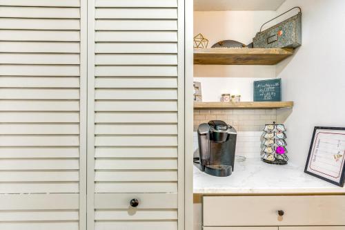 a cupboard in a kitchen with a coffee maker on a counter at 1 Mi to Boat Ramp Home Near Chassahowitzka River! in Homosassa