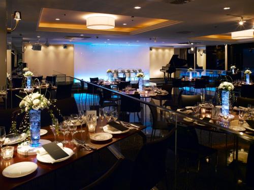a dining room with tables and chairs and a piano at Koriyama View Hotel in Koriyama