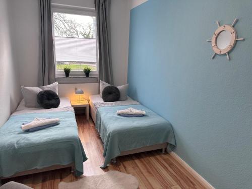 two twin beds in a room with a window at Ferienwohnung NORDLICHT mit Balkon und Smart-TV in Rostock
