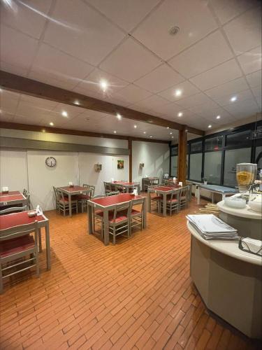 a dining room with tables and chairs in a room at The Originals Access, Hôtel Arum, Remiremont in Remiremont