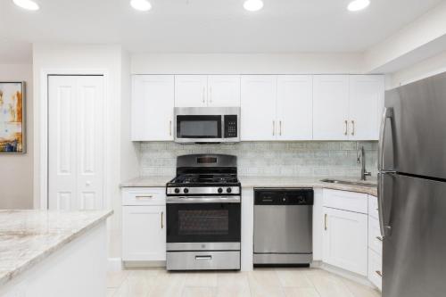 a white kitchen with a stove and a microwave at Westgate Leisure Resort in Orlando