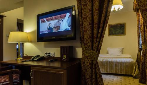 a hotel room with a tv and a bed at Zamek Gniew - Pałac Marysieńki in Gniew