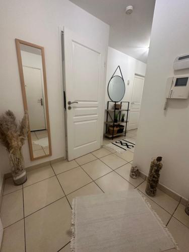 Cette chambre comprend un miroir et une porte blanche. dans l'établissement Apparte Palmeraie, à Montpellier