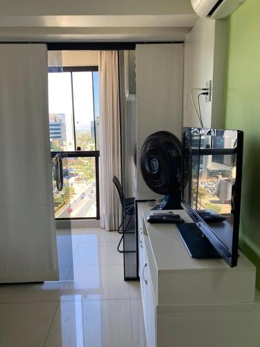 a room with a desk with a computer and a window at Garvey Park Hotel in Brasilia