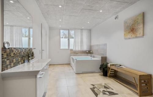 a bathroom with two sinks and a bath tub at 5 Bedroom Amazing Home In Herning in Herning