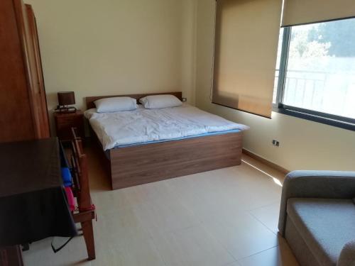 una piccola camera da letto con un letto e una finestra di Dream Valley حلم الوادي a Sirjbāl