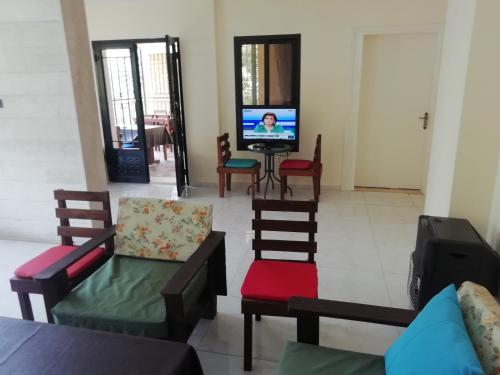 un soggiorno con sedie e TV di Dream Valley حلم الوادي a Sirjbāl