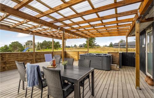 a patio with a table and chairs under a pergola at Lovely Home In Ebeltoft With Sauna in Ebeltoft