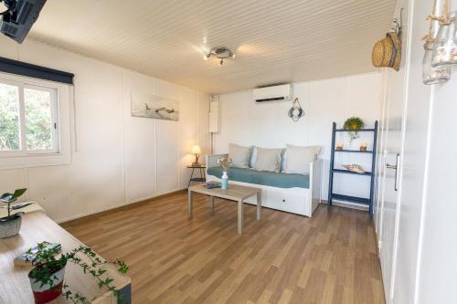 un salon avec un lit et une table dans l'établissement La Roche, cabanon cosy les pieds dans l'eau avec vue exceptionnelle, à Hyères