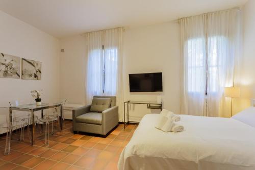 una camera da letto con un letto, un tavolo e una sedia di Yourbanflat Il Chiostro Nascosto a Padova