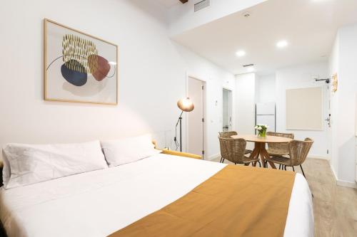 a bedroom with a bed and a table with chairs at Moontels Plaza de Vannes in Valencia