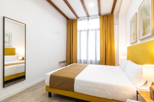a bedroom with a large bed and a mirror at Moontels Plaza de Vannes in Valencia