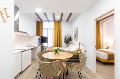 a room with a table and chairs and a bed at Moontels Plaza de Vannes in Valencia