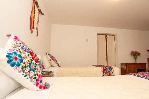 a bedroom with two beds and a couch at La Rosa Wellness Lodge in Urubamba