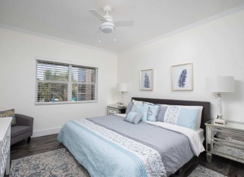 a white bedroom with a bed and a window at Beach Living at Plantation Village BLGS in George Town