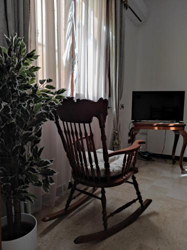 a wooden rocking chair in a living room with a television at Da Marilù in Mazara del Vallo