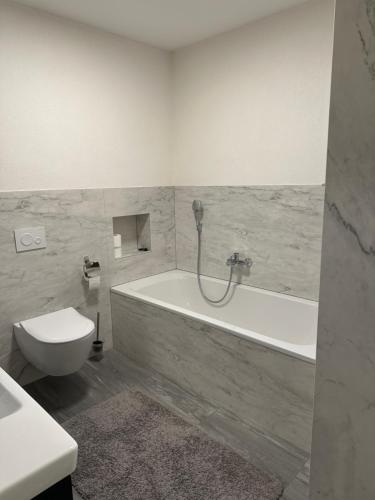 a bathroom with a tub and a toilet and a sink at Schöne Ferienwohnung im Landhaus in Stadtlengsfeld