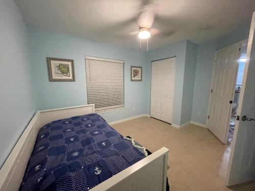 a bedroom with a bed and a blue wall at Affordable & cozy duplex close to the beach! in Palm Coast