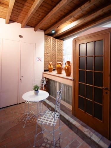 a room with a table and chairs and a door at Mondo Antico B&B in Cesena