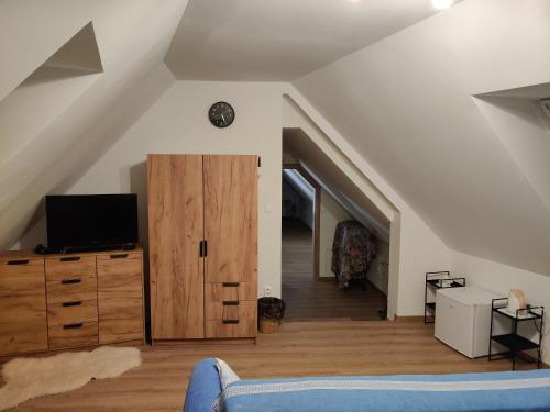 a living room with a blue couch and a tv at Ubytovanie Pod Rotundou in Skalica