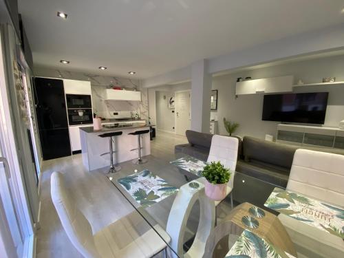 a living room with a glass table and a kitchen at Piso deluxe centro cerca del BEC in Barakaldo