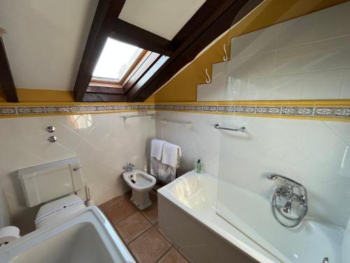 a bathroom with a toilet and a tub and a sink at Posada San Tirso in Toñanes