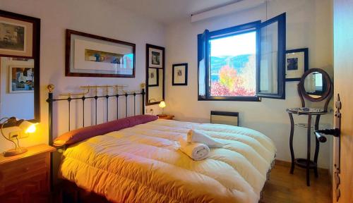 a bedroom with a large bed and a window at Apartamento con chimenea y vistas Falcó 10 in Pla de l'Ermita