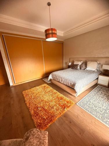 a bedroom with a bed and two rugs at Ferme de luxe in O Ben Slimane