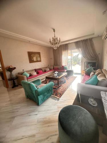 a living room with a couch and chairs and a table at Ferme de luxe in O Ben Slimane
