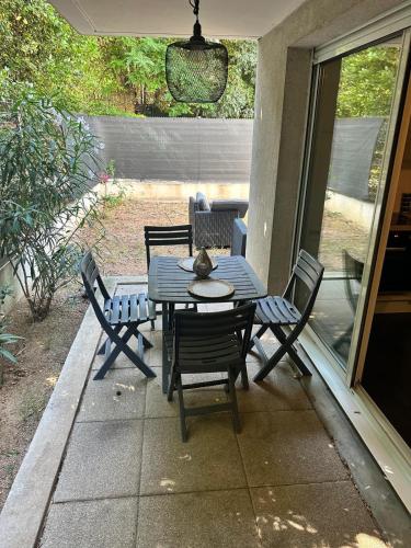 une table et des chaises assises sur une terrasse dans l'établissement Appartement du M T2 Montpellier, à Montpellier