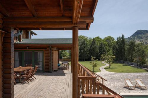 a wooden deck with a table and chairs on it at Chalet Styga Kalavrita in Kalavrita