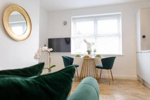 a living room with a table and chairs and a mirror at Boutique City Centre Apartments in Cardiff
