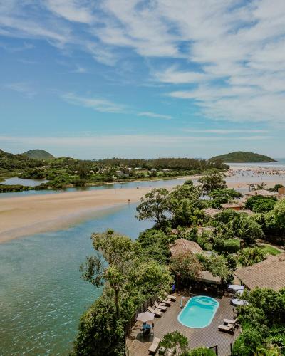 an aerial view of a beach with chairs and a swimming pool at Pousada Mevlana Garden in Barra de Ibiraquera