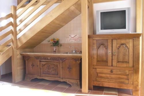 a bathroom with a sink and a tv on a wooden cabinet at Faluszéli Vendégház - Boncz Porta in Nagyrákos
