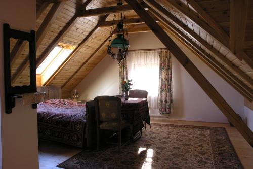 a bedroom with a bed and a table and a window at Faluszéli Vendégház - Boncz Porta in Nagyrákos
