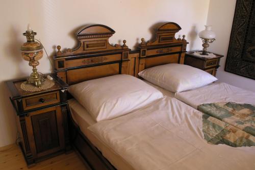 two beds with wooden headboards in a bedroom at Faluszéli Vendégház - Boncz Porta in Nagyrákos