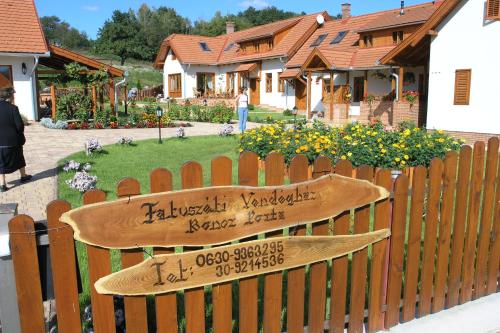 a wooden bench with a sign on a fence at Faluszéli Vendégház - Boncz Porta in Nagyrákos