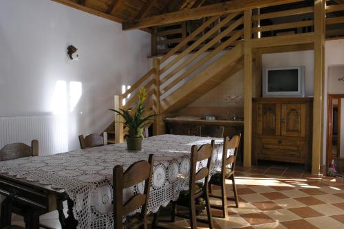 a dining room with a table and chairs and a television at Faluszéli Vendégház - Boncz Porta in Nagyrákos