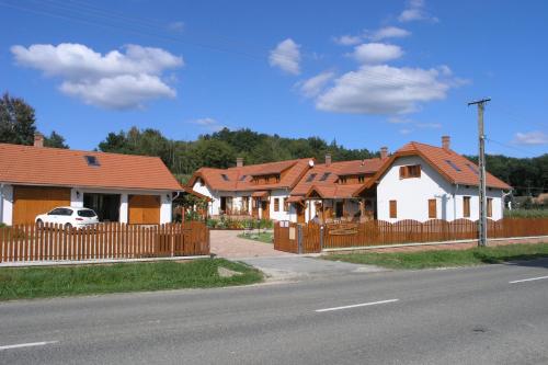 a row of houses with red roofs on a street at Faluszéli Vendégház - Boncz Porta in Nagyrákos