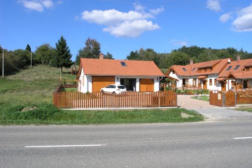 a house with a fence and a car in front of it at Faluszéli Vendégház - Boncz Porta in Nagyrákos