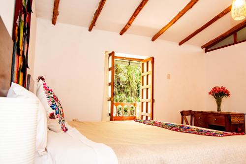 a bedroom with a bed and a window at La Rosa Wellness Lodge in Urubamba